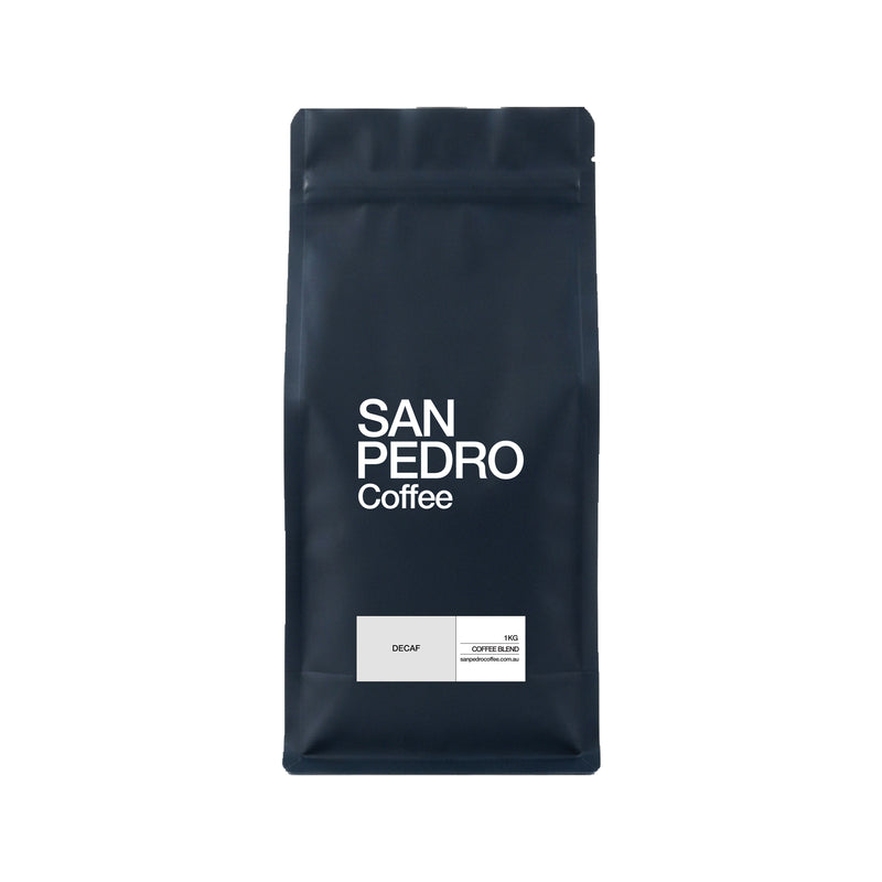 A dark navy blue stand-up coffee bag with white text reading 'SAN PEDRO Coffee' and a small white label near the bottom that says 'DECAF' and '100% COFFEE BLEND'.