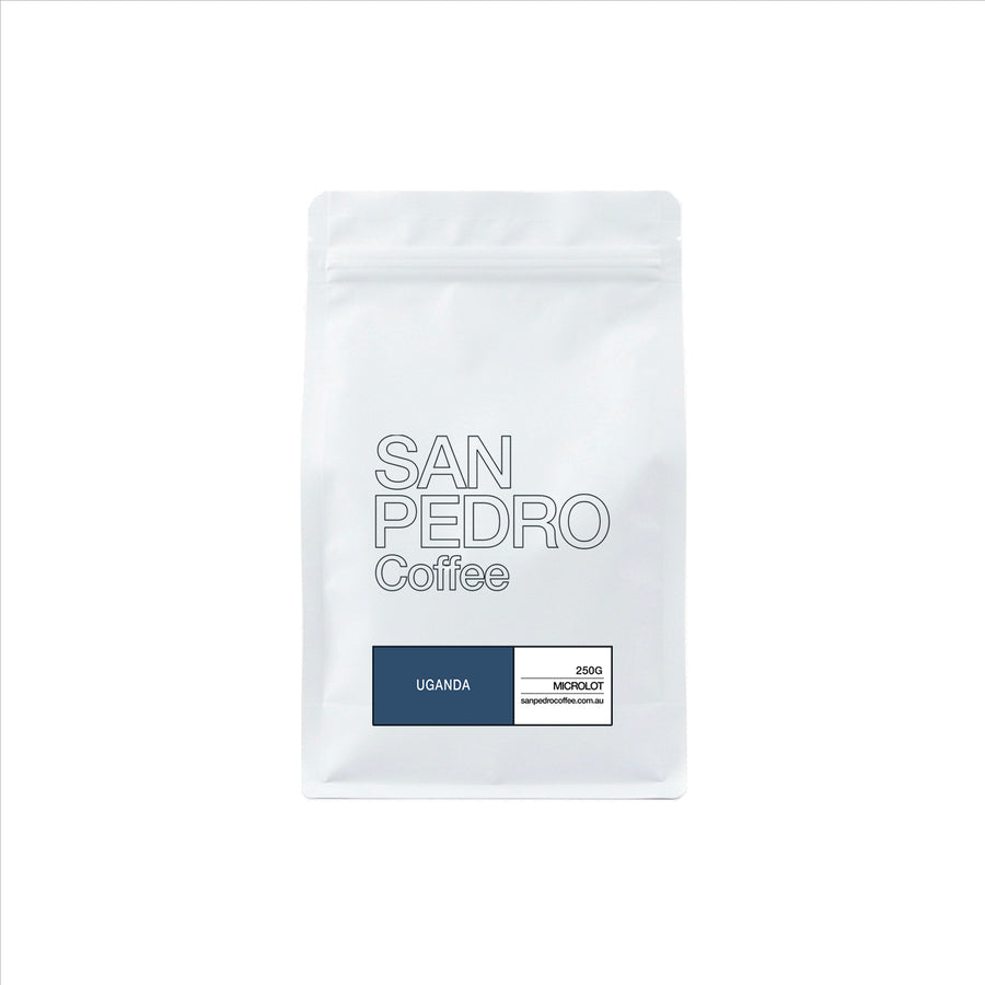 A white stand-up coffee bag with the text 'SAN PEDRO Coffee' and a dark blue label at the bottom that reads 'UGANDA' alongside other small text details.